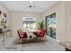 Virtually staged dining area with modern table and red chairs, leading to a backyard at 6160 Lautman Ridge Ct, Las Vegas, NV 89141