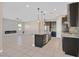 Open concept kitchen with an island, dark cabinets, and stainless steel appliances at 6160 Lautman Ridge Ct, Las Vegas, NV 89141