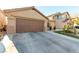 Tan house with brown garage door, cacti, and desert landscaping at 6349 Heather Creek Place Pl, Las Vegas, NV 89122