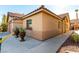 Corner view of tan house with brown door and landscaping at 6349 Heather Creek Place Pl, Las Vegas, NV 89122