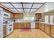 Open kitchen with wood cabinets, white appliances, and a corner sink at 6466 Scotch Pine Cir, Las Vegas, NV 89146
