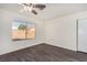 Bright bedroom with dark grey wood-look floors and ceiling fan at 7748 Selby Ct, Las Vegas, NV 89147