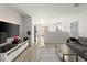 Open living room with kitchen view, gray couch, and wood floors at 104 Masserta Ct, Las Vegas, NV 89183