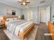 Virtually staged main bedroom with light wood platform bed and en suite bathroom at 480 Sterling Falls Ave, Henderson, NV 89011
