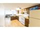 Kitchen with wood cabinets, white appliances, and view of living room at 523 Fir St, Boulder City, NV 89005