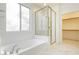 Bright bathroom featuring a soaking tub, glass shower, and walk-in closet at 561 Tecate Valley St, Las Vegas, NV 89138