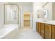 Bathroom with a soaking tub, a glass shower, and a vanity with wood cabinets at 561 Tecate Valley St, Las Vegas, NV 89138