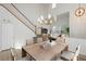 Bright dining room with a modern chandelier and staircase featuring carpeted steps and white banisters at 561 Tecate Valley St, Las Vegas, NV 89138