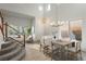 Bright living room with tile flooring, a staircase with carpeted steps, and large windows at 561 Tecate Valley St, Las Vegas, NV 89138