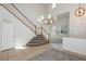 Entryway featuring a modern chandelier, a staircase with carpeted steps, and tile flooring at 561 Tecate Valley St, Las Vegas, NV 89138