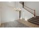 Bright living room with stairs, tile floors, and modern chandelier at 561 Tecate Valley St, Las Vegas, NV 89138