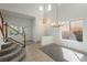 Bright living room with high ceilings, tile floors, and staircase with wooden banister at 561 Tecate Valley St, Las Vegas, NV 89138