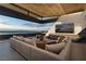 Indoor-outdoor living area with a fireplace, sectional sofa, and expansive views at 705 Dragon Peak Dr, Henderson, NV 89012