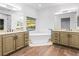 Luxurious bathroom with double vanities, a soaking tub, and wood-look tile floors at 7840 Thunder Echo St, Las Vegas, NV 89131