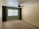 Neutral carpeted bedroom with ceiling fan and natural light from the large window at 8441 Blue Island Ave, Las Vegas, NV 89129