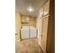 Laundry room with a washer, dryer, built-in shelving, tile floors, and neutral walls offering practicality at 8441 Blue Island Ave, Las Vegas, NV 89129