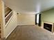 Spacious living room with a fireplace, staircase, neutral paint, carpet, and natural light from a large window at 8441 Blue Island Ave, Las Vegas, NV 89129