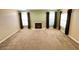 Large living room with a fireplace, neutral walls, large windows, and brown carpet throughout the expansive space at 8441 Blue Island Ave, Las Vegas, NV 89129
