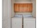 Bright laundry room with washer, dryer and overhead cabinets at 1327 Beehive Ln, Mesquite, NV 89034