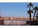 Daytime view of the city skyline over the block wall and trees, with palm trees in the foreground at 3338 Commendation Dr, Las Vegas, NV 89117