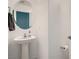 This bathroom has a pedestal sink, round mirror and a towel rack at 377 Yellow Finch Ln, Henderson, NV 89012