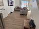 Bright living room with gray sofas, dining table, and wood-look floors at 4043 Asante Cove St, Las Vegas, NV 89115