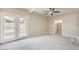 Spacious bedroom with grey carpet, double doors to backyard, and ceiling fan at 5100 Kansas Ave, Las Vegas, NV 89107