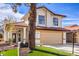 Two-story house with a tan facade, red roof, and a landscaped front yard at 5213 Tamanar Dr, Las Vegas, NV 89130