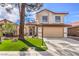 Two-story house with a tan facade, red roof, and a landscaped front yard at 5213 Tamanar Dr, Las Vegas, NV 89130