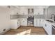 Modern white kitchen with stainless steel appliances and stylish backsplash at 5213 Tamanar Dr, Las Vegas, NV 89130