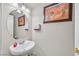 Small bathroom with white sink and vanity, oval mirror at 791 Maranello St, Henderson, NV 89052