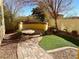 Landscaped backyard with a circular sitting area and artificial turf at 917 Old Creek Way, North Las Vegas, NV 89084