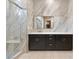 Modern bathroom with marble-look tile, a large vanity, and frameless shower at 949 Twinflower Peak Ct, Las Vegas, NV 89138