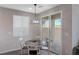 Small dining area with white table and chairs near sliding door at 10122 Ashford Mill Ct, Las Vegas, NV 89178