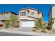 Two story house with white garage door and landscaping at 10122 Ashford Mill Ct, Las Vegas, NV 89178