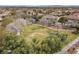 Expansive aerial view showcasing the neighborhood, a grassy park, and distant mountains at 10923 Willow Heights Dr, Las Vegas, NV 89135