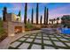 Stunning backyard with stone fireplace, manicured lawn, sparkling pool, and mature trees creating a private oasis at 10923 Willow Heights Dr, Las Vegas, NV 89135