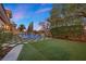 Spacious backyard with lush lawn, mature trees, and a stunning pool area, perfect for outdoor entertaining and relaxation at 10923 Willow Heights Dr, Las Vegas, NV 89135