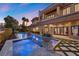 Spacious backyard featuring a sparkling pool and spa, complemented by an outdoor kitchen and lush landscaping at 10923 Willow Heights Dr, Las Vegas, NV 89135