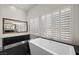 Modern bathroom with soaking tub, shutters, and elegant design at 10923 Willow Heights Dr, Las Vegas, NV 89135