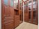 Custom designed walk-in closet with wooden shelves and drawers with glass door cabinets for organized storage at 10923 Willow Heights Dr, Las Vegas, NV 89135