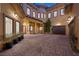 Expansive brick courtyard with direct garage access, multiple windows and entry points, plus lush landscaping at 10923 Willow Heights Dr, Las Vegas, NV 89135