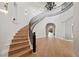 Elegant foyer showcasing a curved staircase with iron railing, hardwood floors, and arched doorways at 10923 Willow Heights Dr, Las Vegas, NV 89135