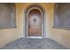 Close-up of the arched, wooden front door with decorative metalwork and stone surround at 10923 Willow Heights Dr, Las Vegas, NV 89135