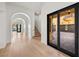 Bright hallway featuring hardwood floors, arched doorways, access to the garage, and backyard pool views at 10923 Willow Heights Dr, Las Vegas, NV 89135