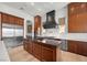Modern kitchen featuring dark wood cabinets, a large island, and stainless steel appliances at 10923 Willow Heights Dr, Las Vegas, NV 89135