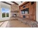 Inviting living room with a stone fireplace, wooden beams and custom built-ins surrounding a large screen tv at 10923 Willow Heights Dr, Las Vegas, NV 89135