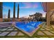 Beautiful backyard pool featuring elegant tile work, waterfall features, lush landscaping, and seamless integration with the patio at 10923 Willow Heights Dr, Las Vegas, NV 89135