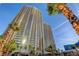 Stunning exterior view of a high-rise building with sleek design and towering palm trees at 135 E Harmon Ave # 2721, Las Vegas, NV 89109