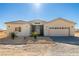 Single-story house with light beige exterior, two-car garage, and landscaping at 251 Glenoaks St, Pahrump, NV 89048